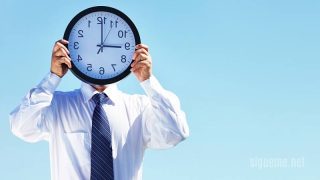 Hombre cubre su rostro con un reloj concepto tiempo