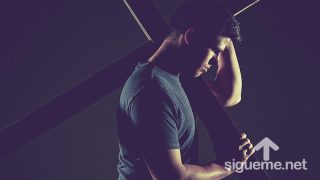 Joven cristiano cargando la cruz de Jesús