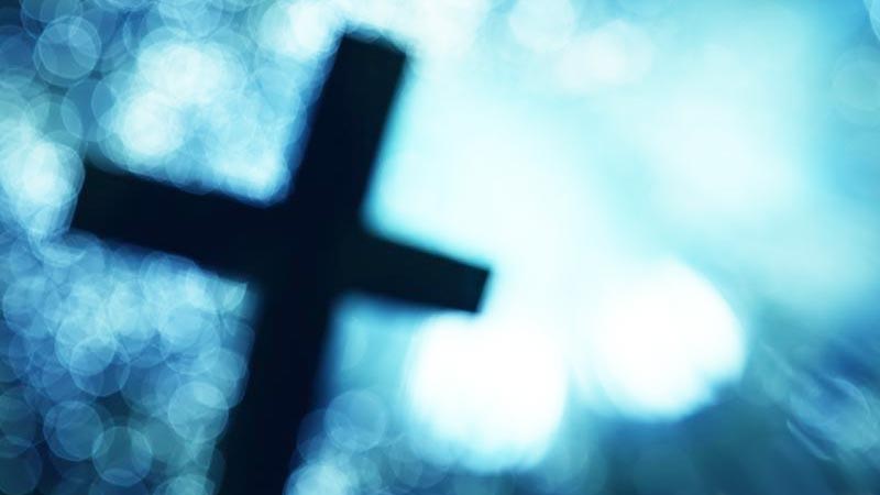 Cruz de Cristo difusa entre luces