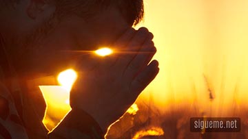 Hombre cristiano orando a Dios al amanecer