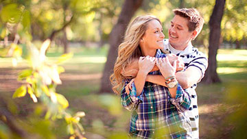 Matrimonio Joven sonriendo abrazados al aire libre