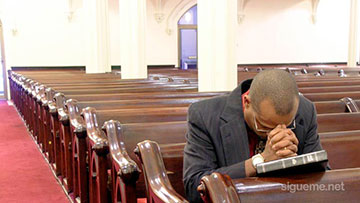 Ministro cristiano orando a Dios en la iglesia