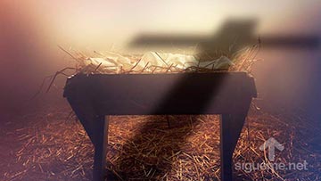 La cuna de Jesus en el pesebre atravesado por la sombra de una cruz